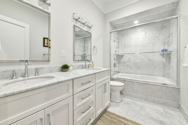 a bathroom with a double vanity sink toilet and shower