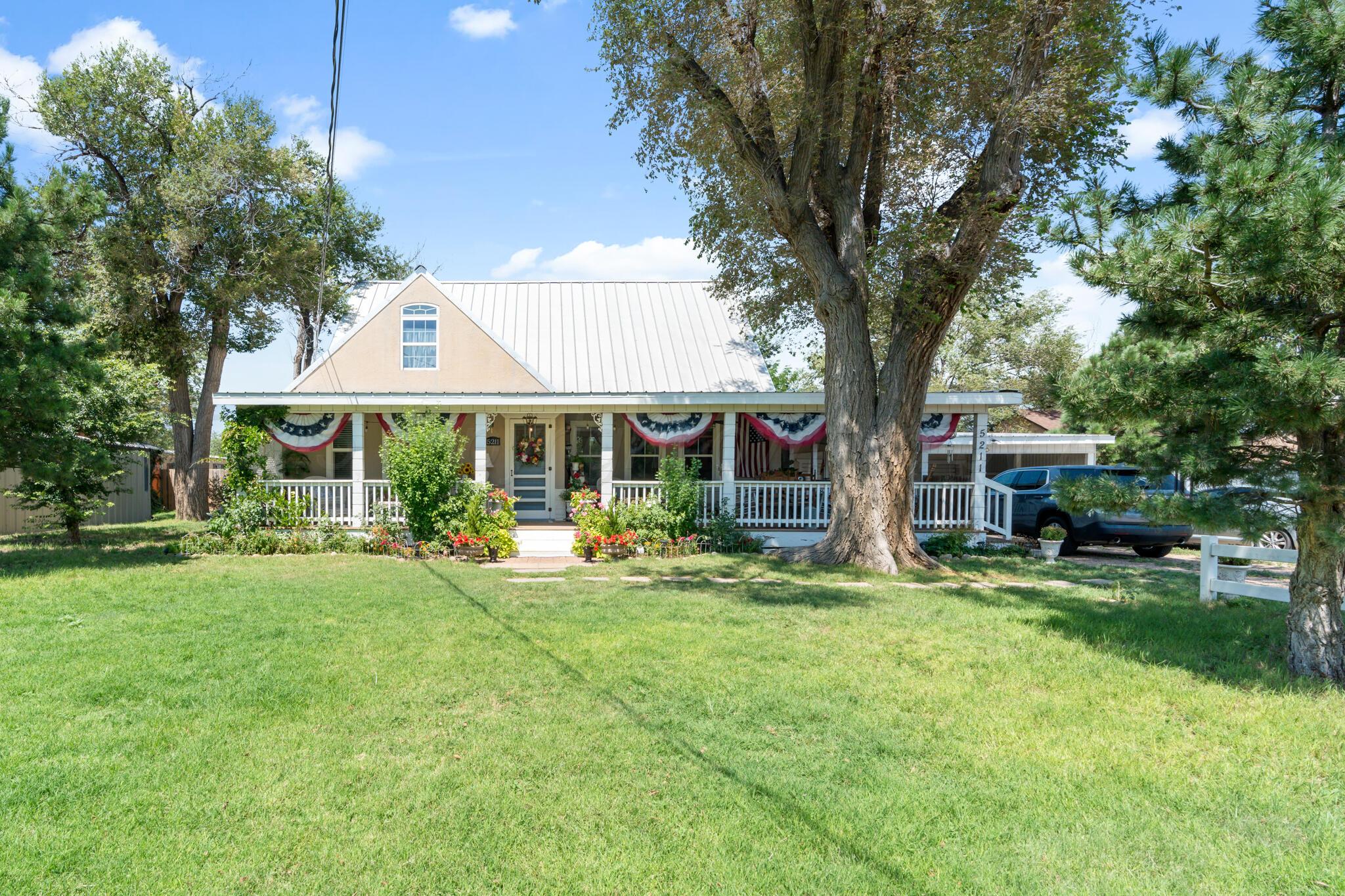 a front view of a house with a yard and trees