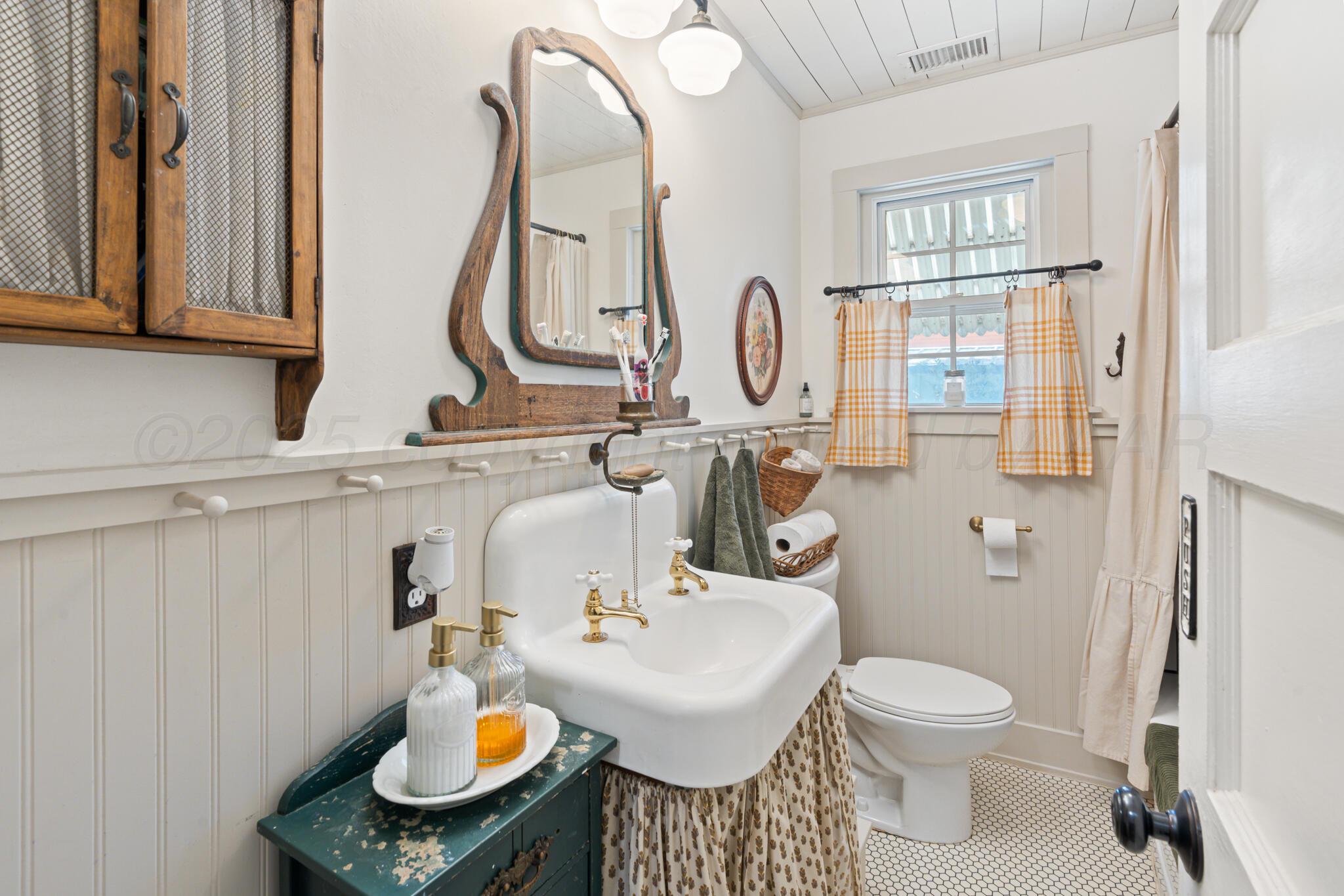 5211 River Road Amarillo, TX 79108 - Photo 21 of 39 a bathroom with a sink toilet and a mirror
