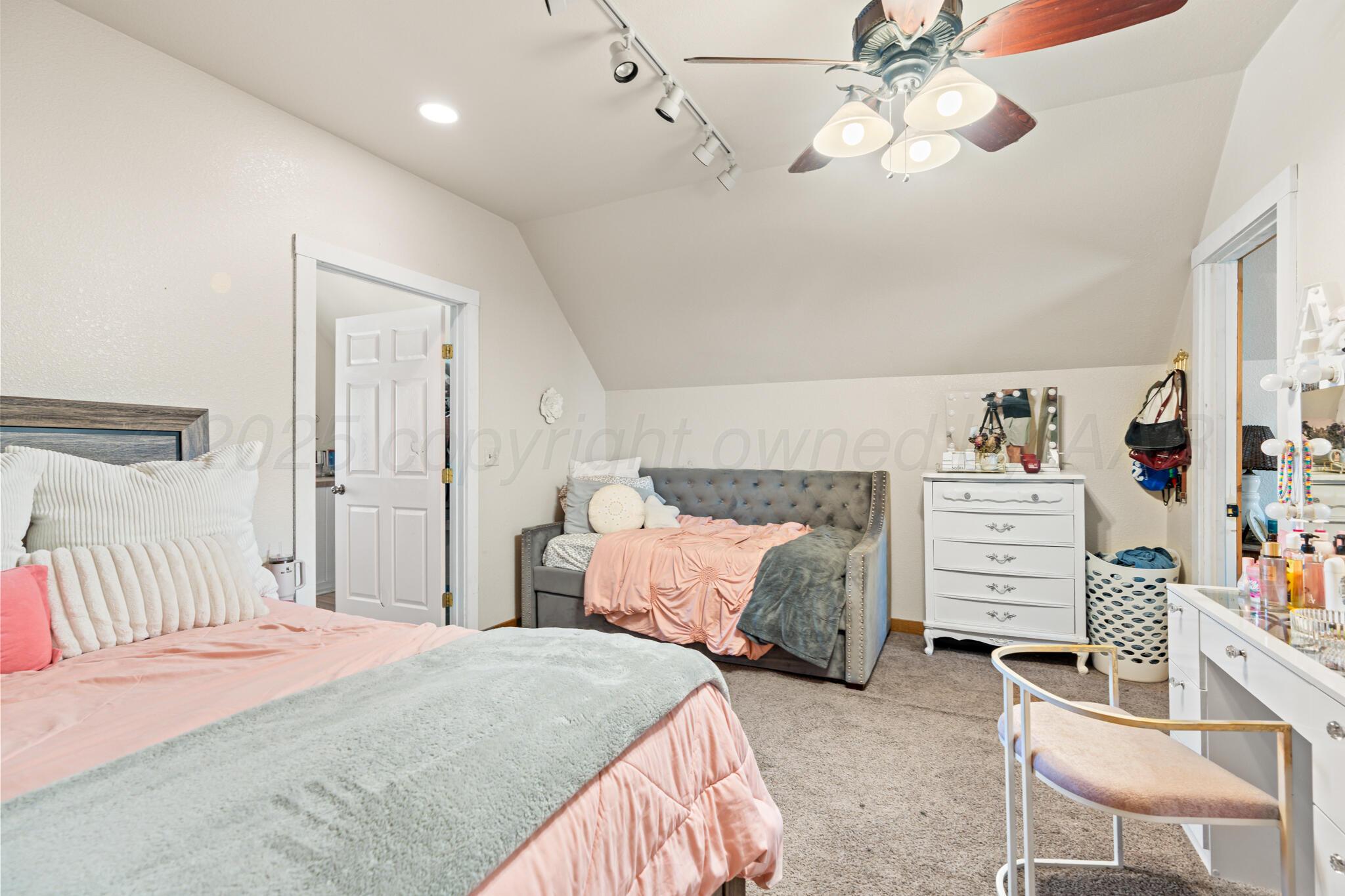 5211 River Road Amarillo, TX 79108 - Photo 27 of 39 a bedroom with a bed and a chandelier