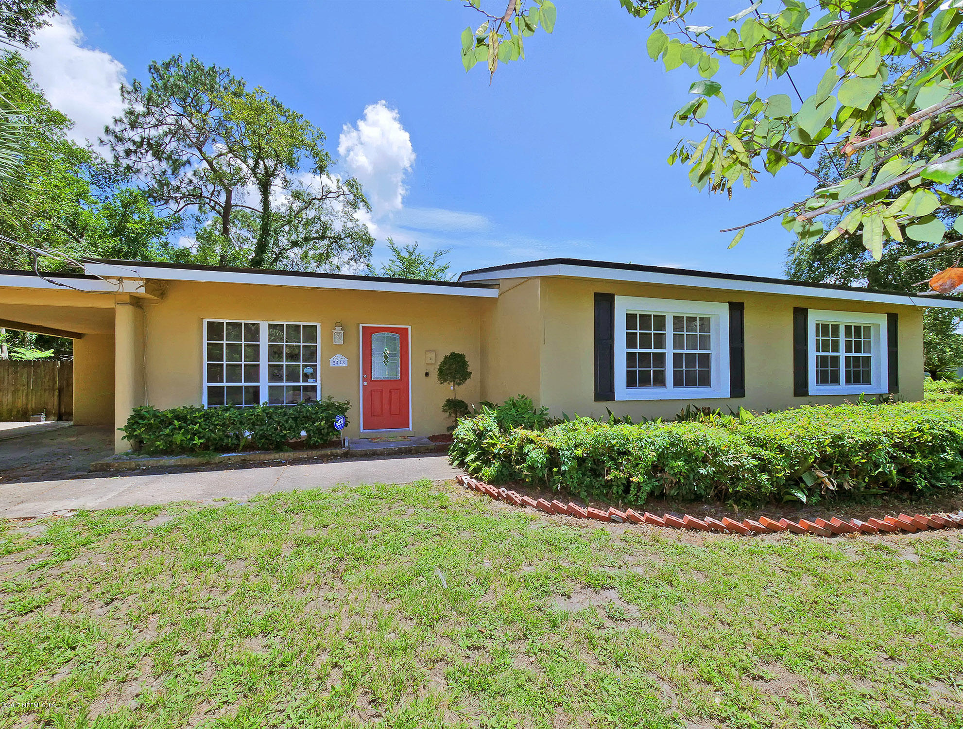 2448 Clemson Road Jacksonville, FL 32217 - Photo 1 of 21 a front view of a house with garden