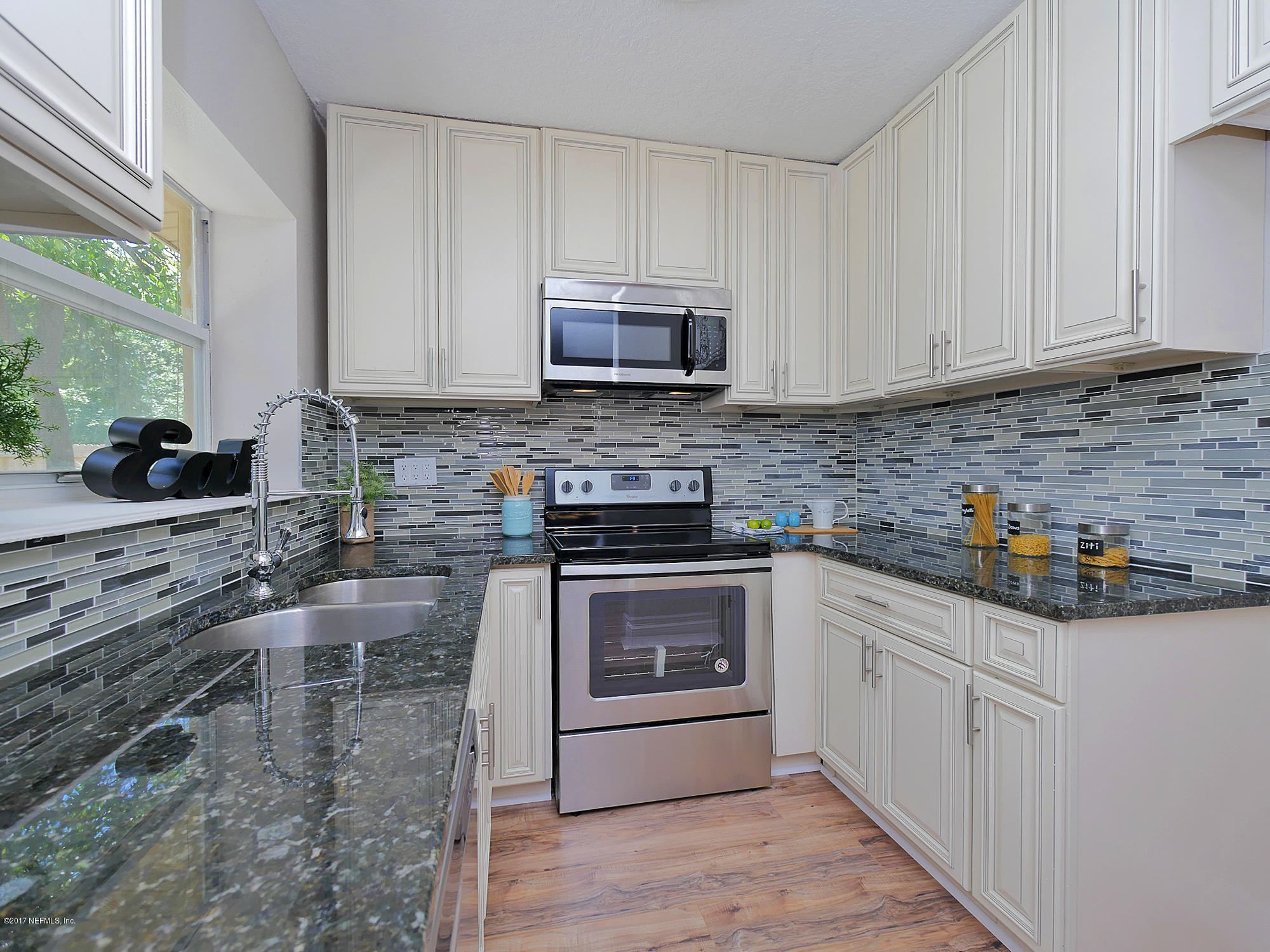 2448 Clemson Road Jacksonville, FL 32217 - Photo 7 of 21 a kitchen with granite countertop a sink a stove and cabinets