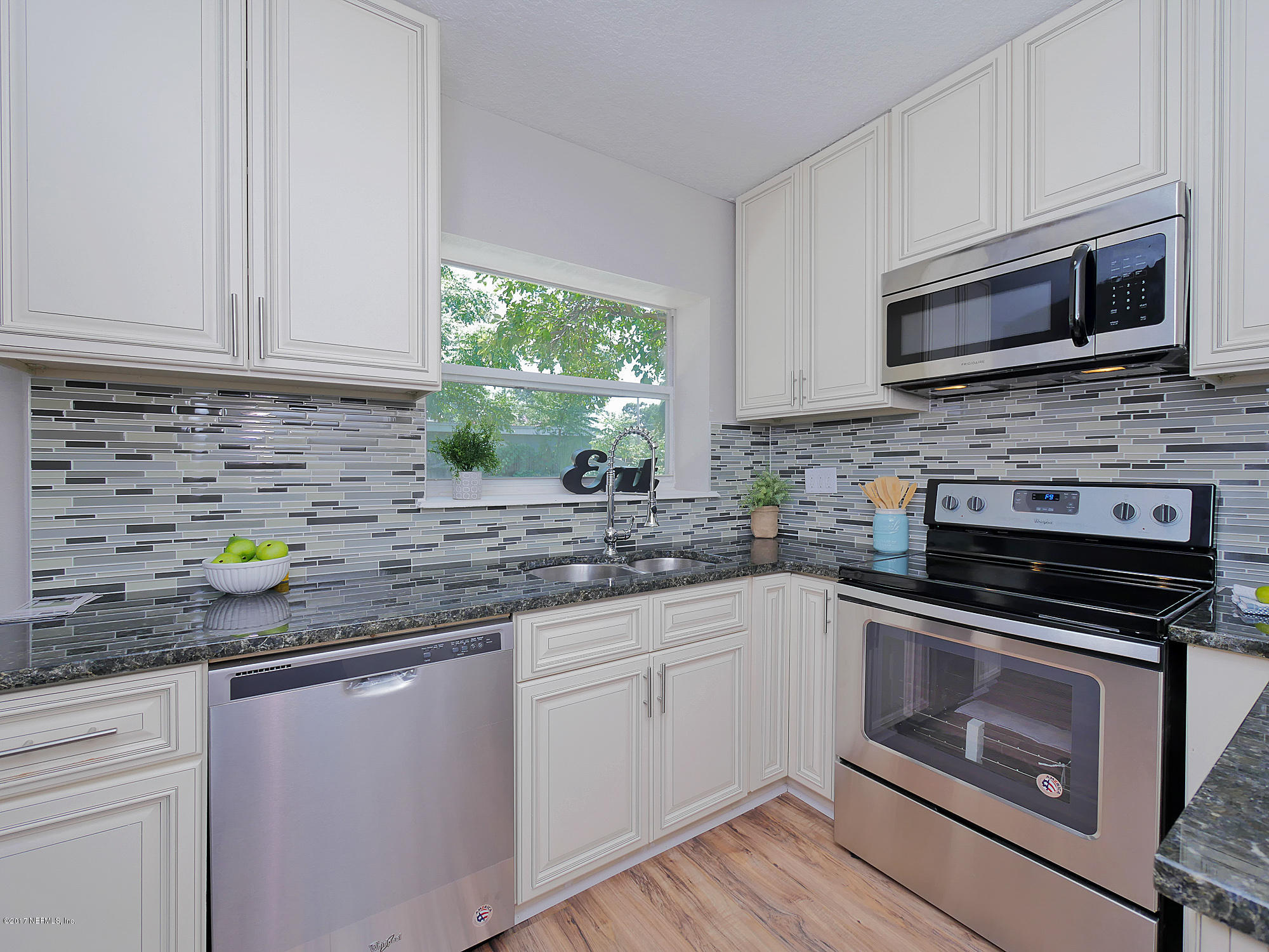 2448 Clemson Road Jacksonville, FL 32217 - Photo 8 of 21 a kitchen with stainless steel appliances granite countertop a sink a stove a microwave and wooden cabinets
