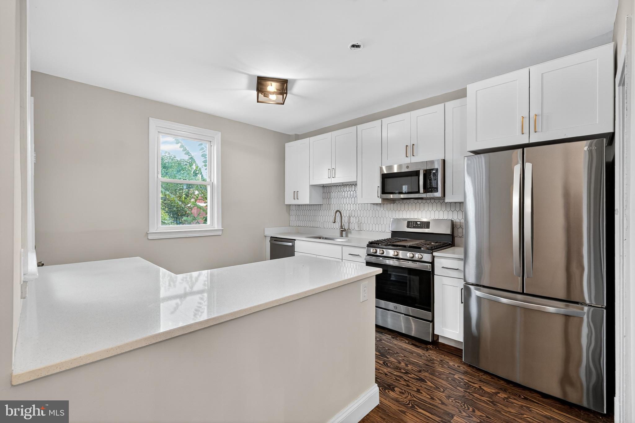 5221 2nd Street Northwest Washington, DC 20011 - Photo 10 of 39 a kitchen with white cabinets and stainless steel appliances