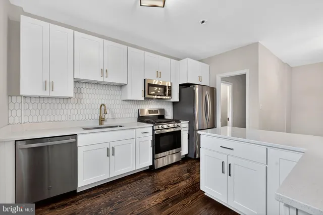 a kitchen with white cabinets and stainless steel appliances