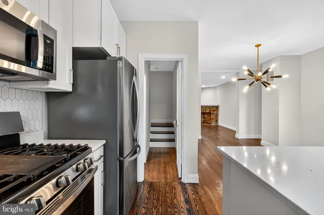 a kitchen with cabinets stainless steel appliances a sink and wooden floor
