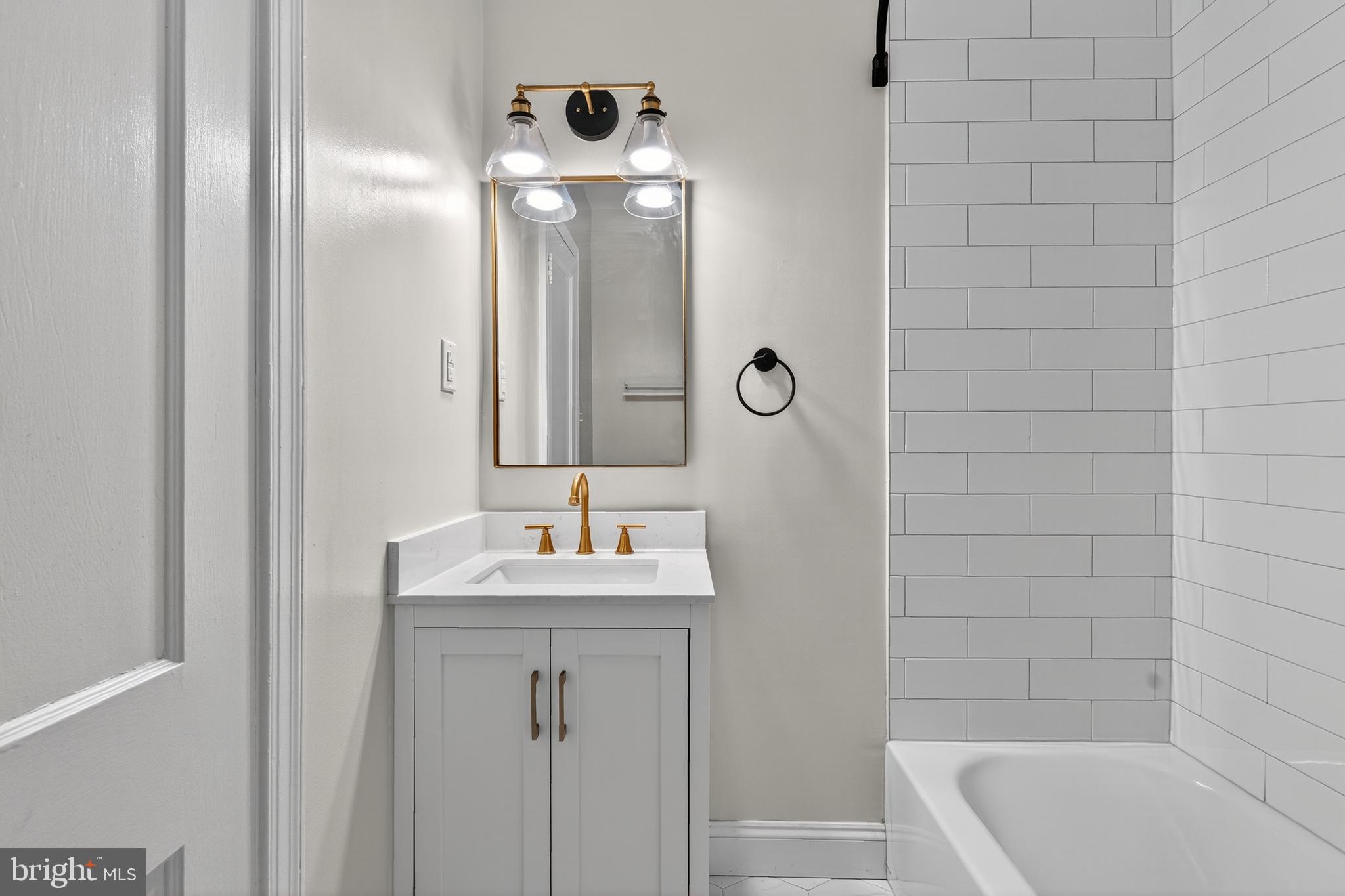 5221 2nd Street Northwest Washington, DC 20011 - Photo 16 of 39 a bathroom with a tub a sink and mirror