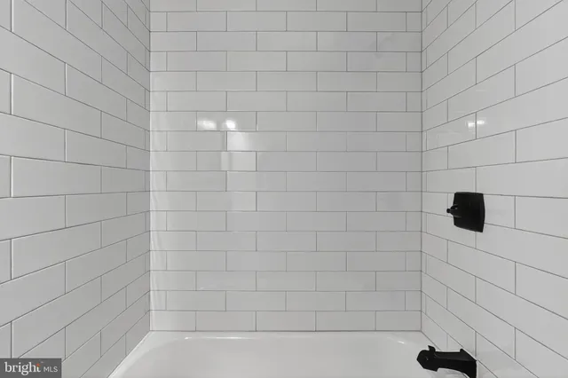 a bathroom with a tub a sink and mirror