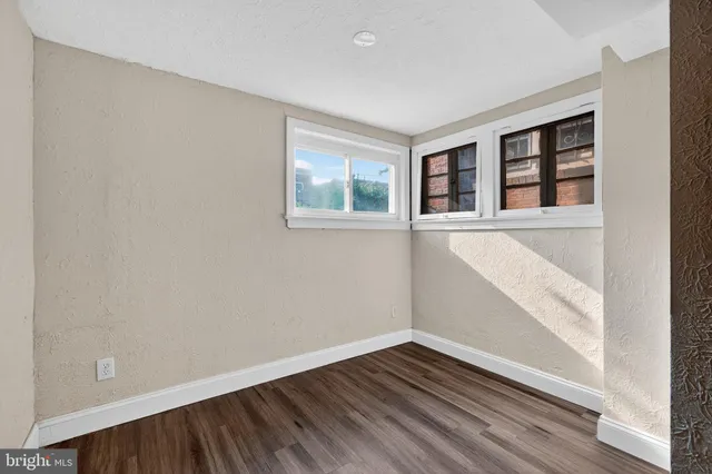 a view of empty room with wooden floor and fireplace