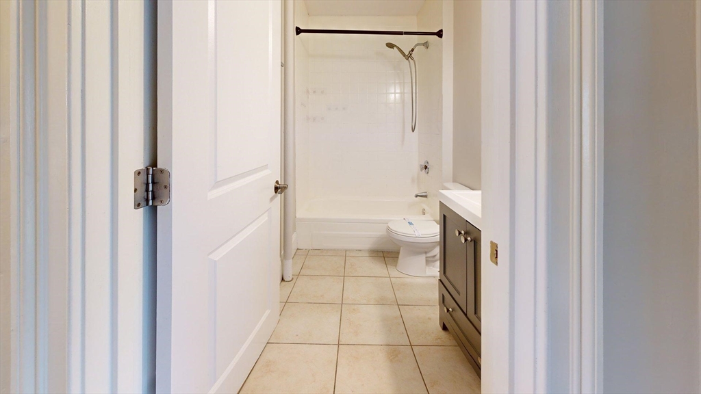 133 Paris Street, Unit 2 Boston, MA 02128 - Photo 19 of 26 a bathroom with a granite countertop shower and a toilet