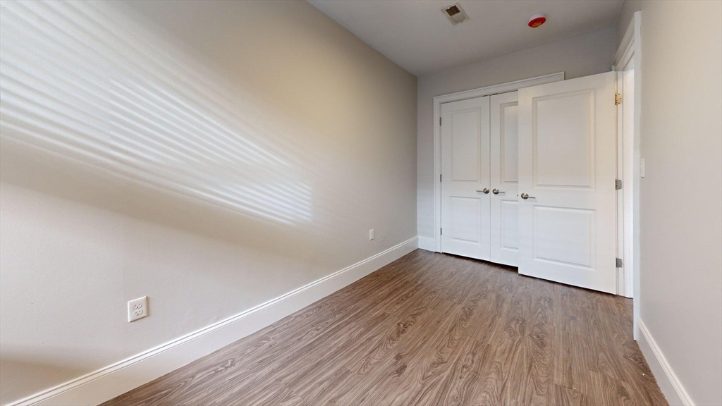 133 Paris Street, Unit 2 Boston, MA 02128 - Photo 20 of 26 a view of an empty room and wooden floor