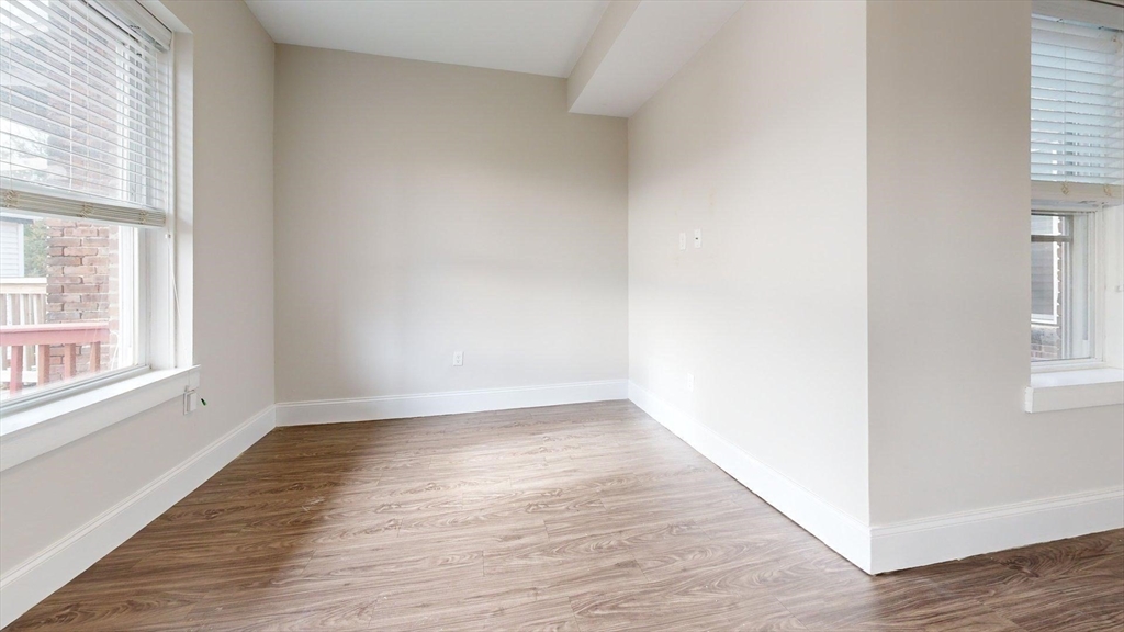 133 Paris Street, Unit 2 Boston, MA 02128 - Photo 25 of 26 an empty room with wooden floor and windows