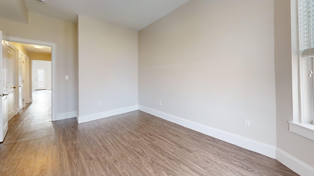 133 Paris Street, Unit 2 Boston, MA 02128 - Photo 3 of 26 a view of an empty room and wooden floor