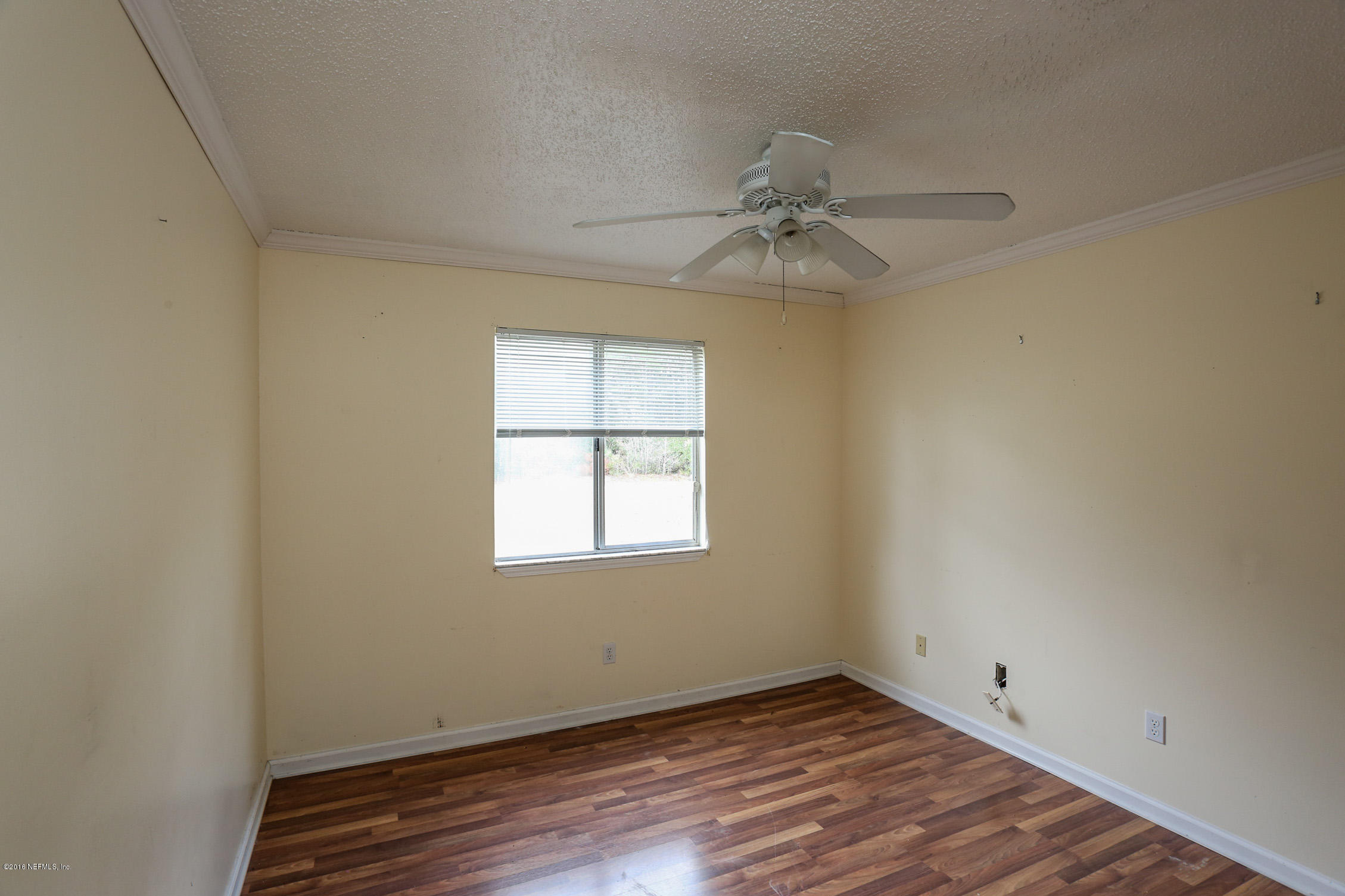 3165 Kings Road St. Augustine, FL 32086 - Photo 10 of 15 an empty room with wooden floor fan and windows