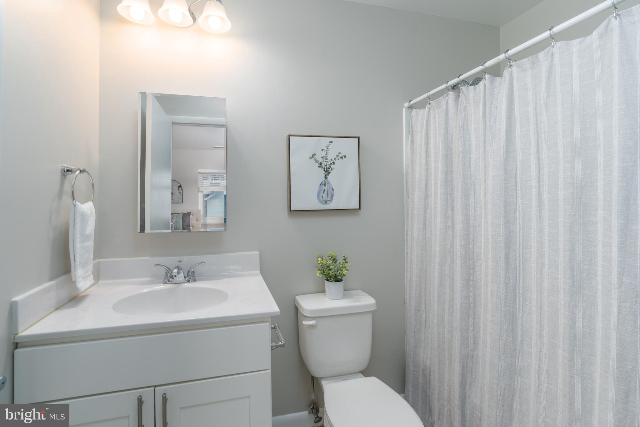 2213 Lowells Glen Road, Unit L Baltimore, MD 21234 - Photo 13 of 26 a bathroom with a toilet a sink and a mirror