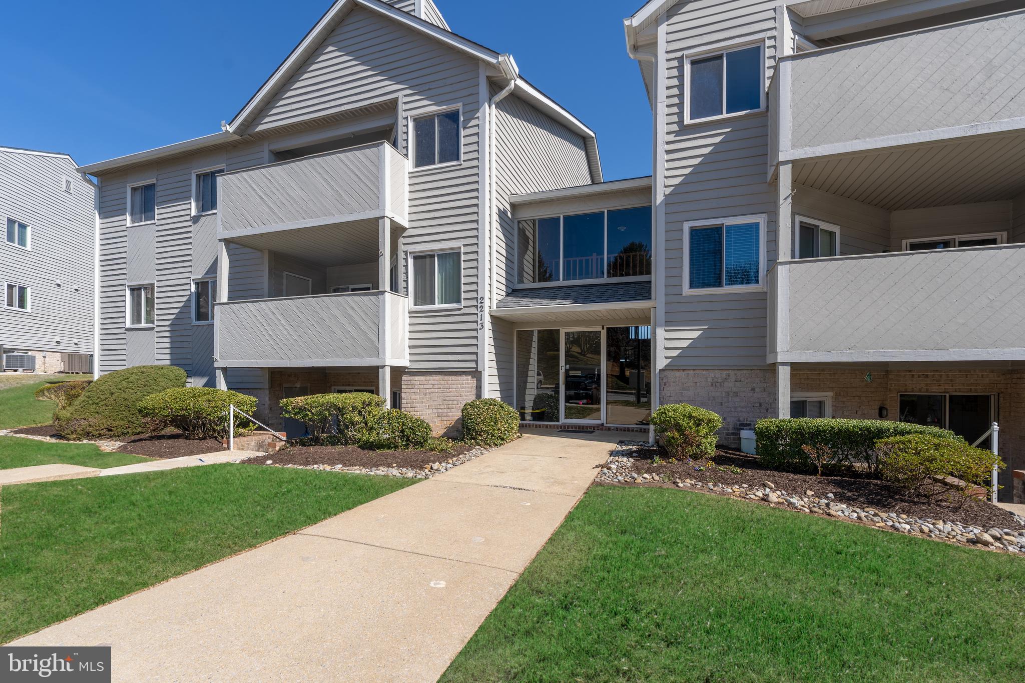 2213 Lowells Glen Road, Unit L Baltimore, MD 21234 - Photo 25 of 26 a front view of a house with a yard and garage