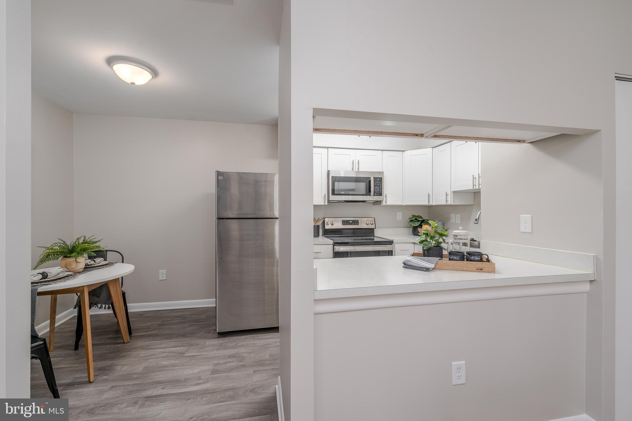 2213 Lowells Glen Road, Unit L Baltimore, MD 21234 - Photo 9 of 26 a kitchen with a refrigerator a stove a dining table and chairs