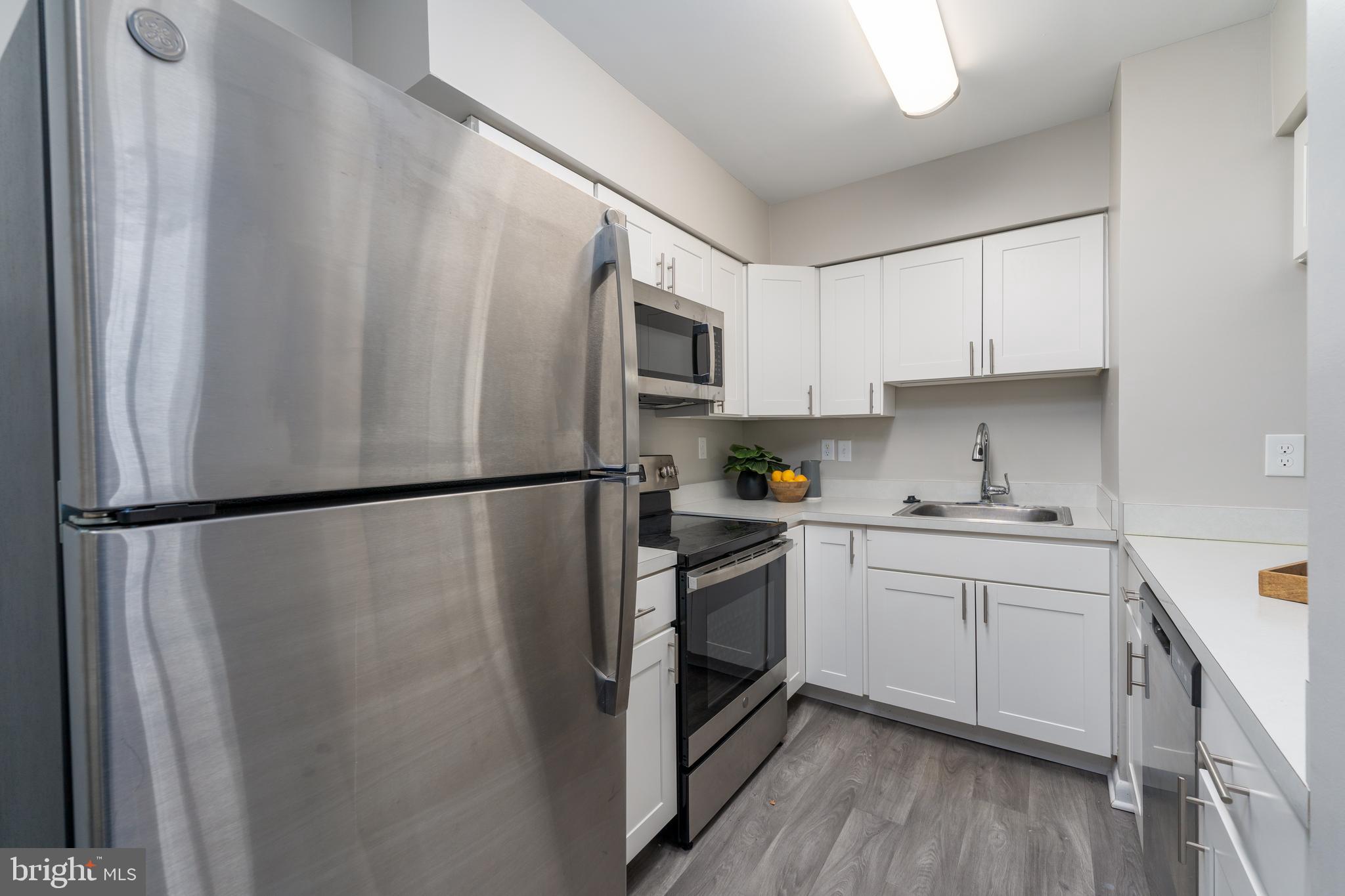 2213 Lowells Glen Road, Unit L Baltimore, MD 21234 - Photo 10 of 26 a kitchen with stainless steel appliances a refrigerator a sink a stove top oven and cabinets