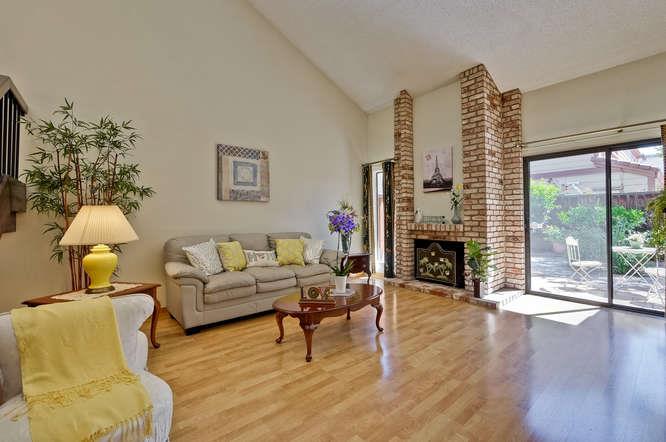 1064 Dempsey Road Milpitas, CA 95035 - Photo 9 of 39 a living room with furniture a fireplace and a floor to ceiling window