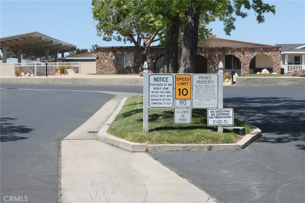 a sign board with a street sign and a small yard
