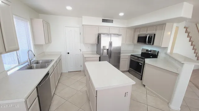 an empty room with windows and chandelier fan