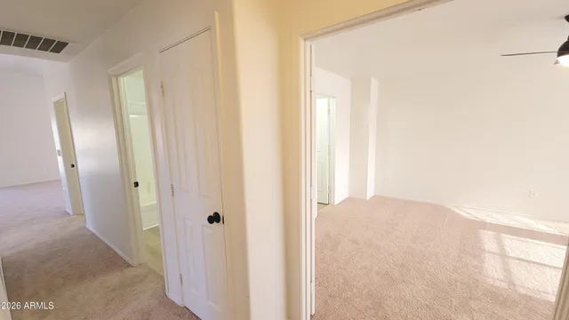 an empty room with a window and a fan