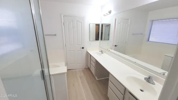 a spacious bathroom with a double vanity sink a mirror and a bathtub