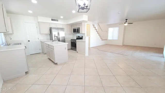 an empty room with windows and ceiling fan