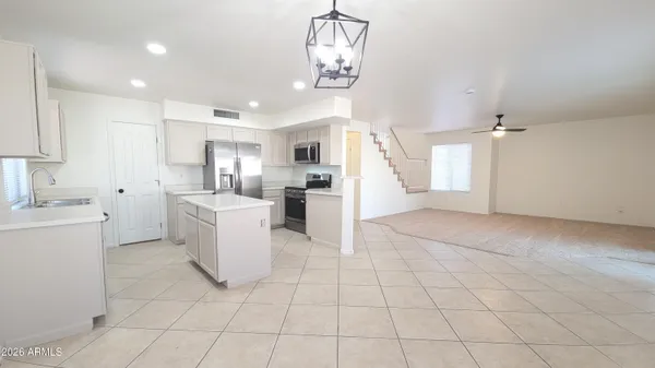 a view of a kitchen with furniture and stainless steel appliances