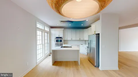 a kitchen with stainless steel appliances a refrigerator and a stove top oven