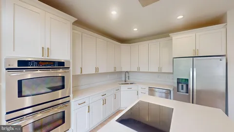 a kitchen with cabinets stainless steel appliances and sink