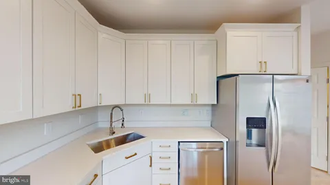 a kitchen with a sink a refrigerator and cabinets