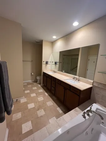 a large bathroom with a sink mirror and a bath tub