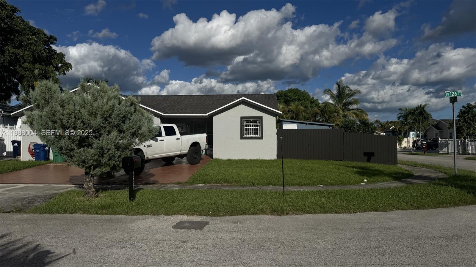 a view of a house next to a yard with big trees