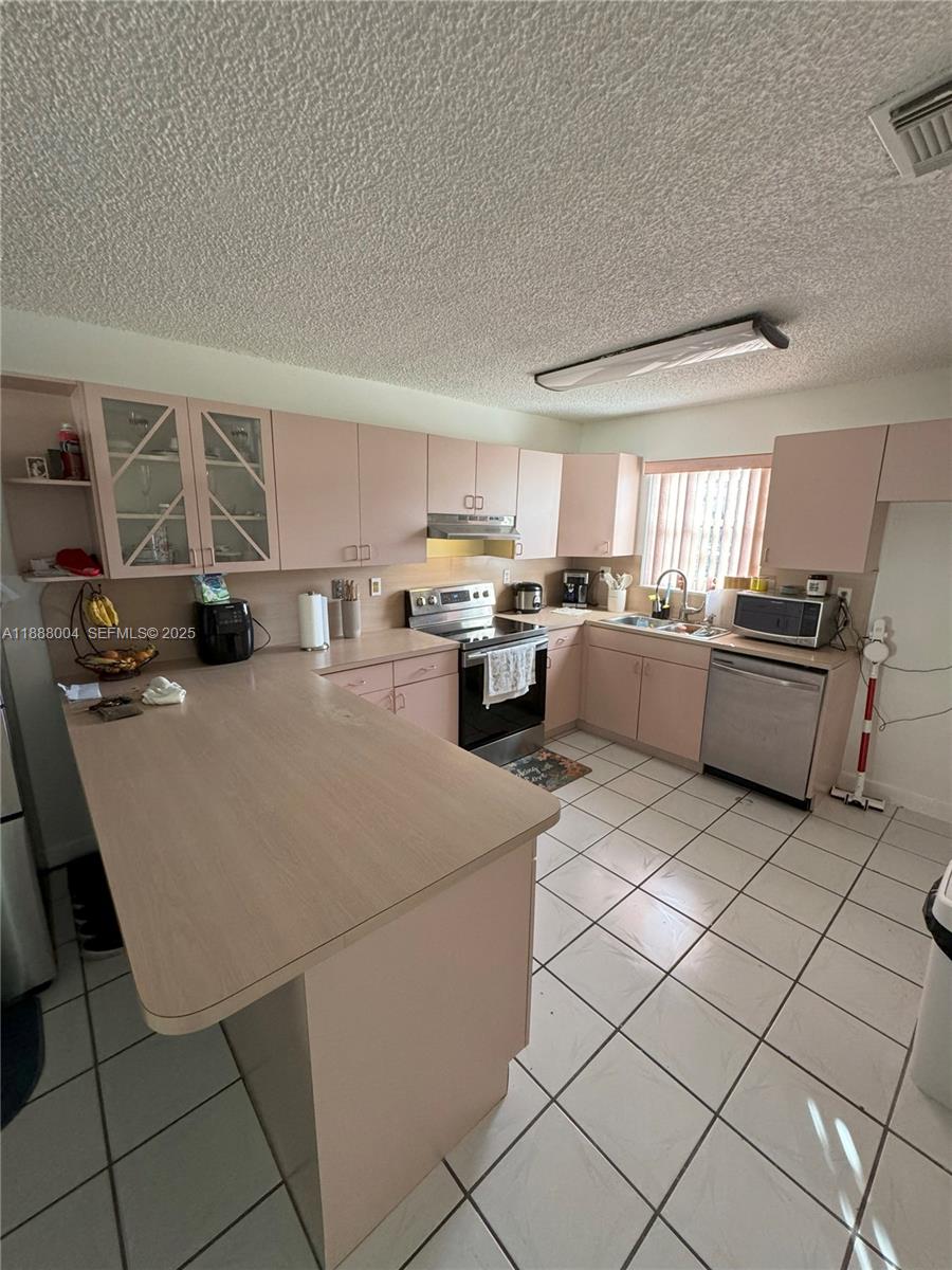 20923 Southwest 126th Court Miami, FL 33177 - Photo 14 of 19 a kitchen with stainless steel appliances granite countertop a sink dishwasher stove top oven and cabinets