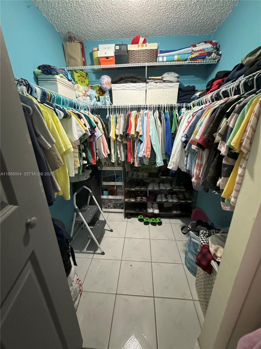 20923 Southwest 126th Court Miami, FL 33177 - Photo 10 of 19 a view of walk in closet with clothes and shoes