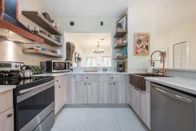 a kitchen with stainless steel appliances granite countertop sink refrigerator dining table and chairs