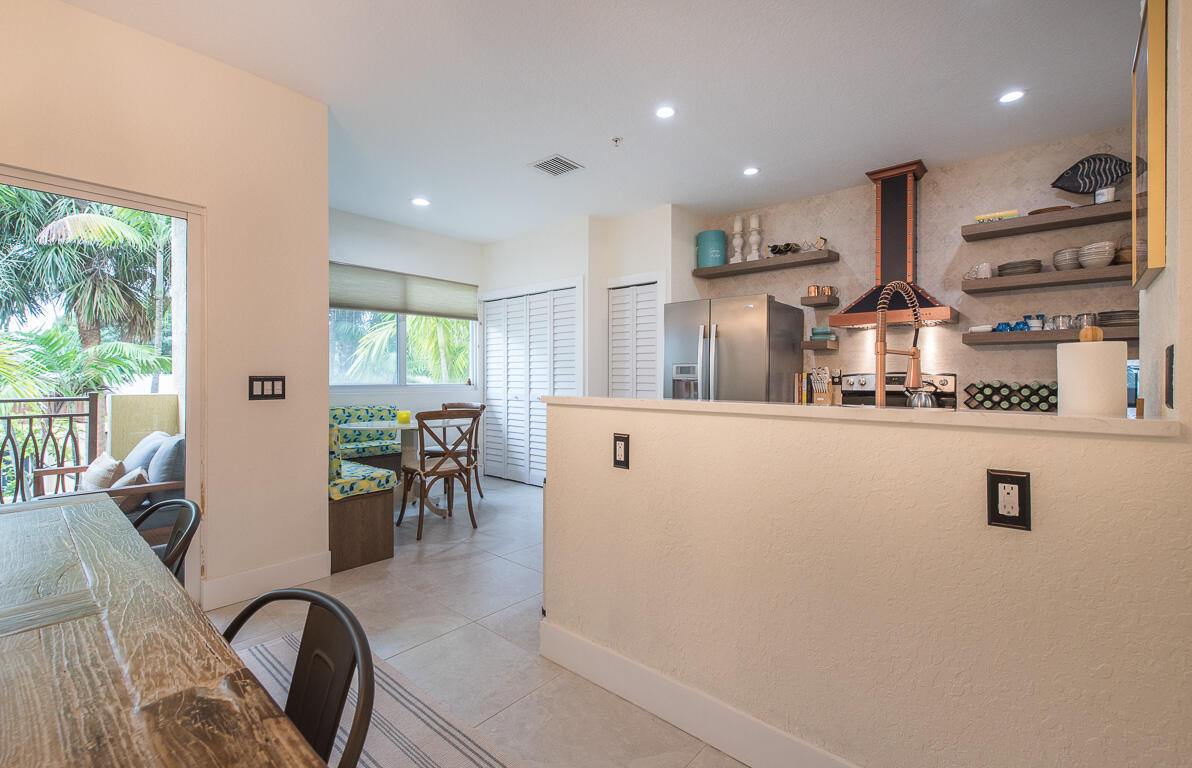 1910 Coastal Bay Boulevard Boynton Beach, FL 33435 - Photo 14 of 64 a kitchen with stainless steel appliances granite countertop sink refrigerator dining table and chairs