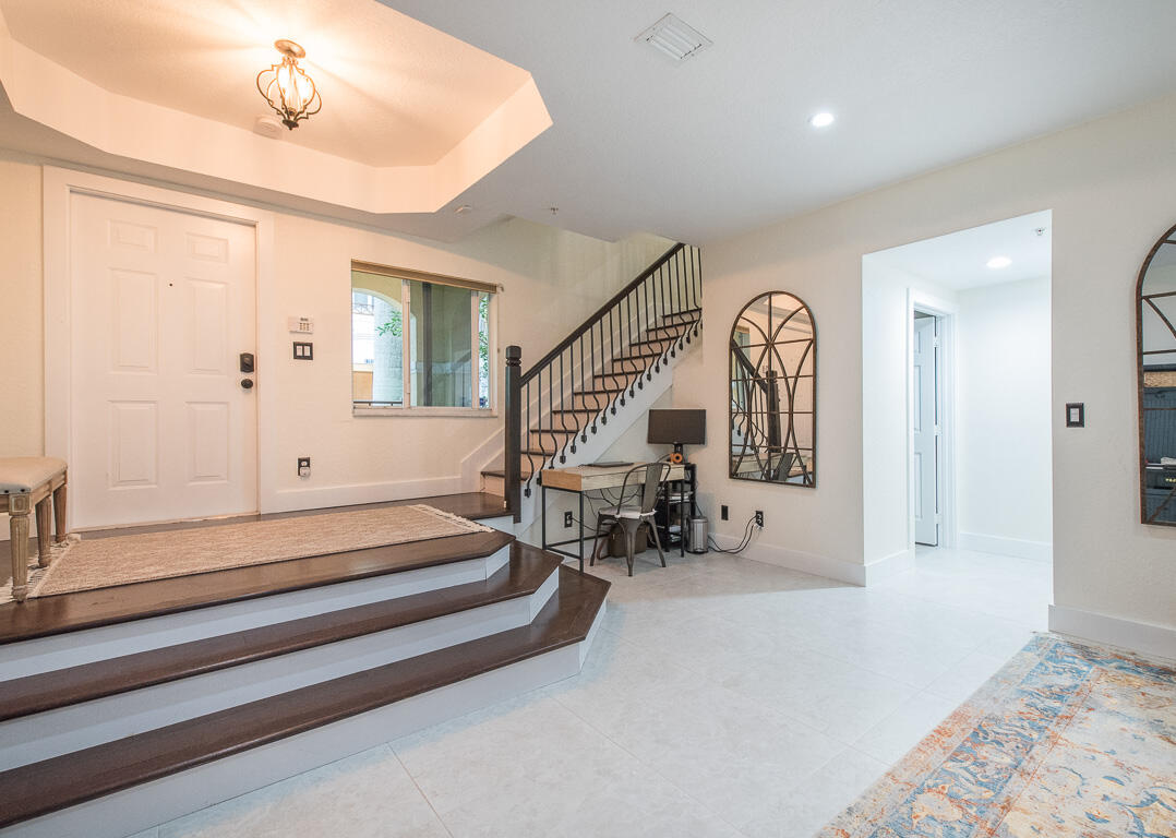 1910 Coastal Bay Boulevard Boynton Beach, FL 33435 - Photo 17 of 64 a spacious bedroom with a bed and a chandelier