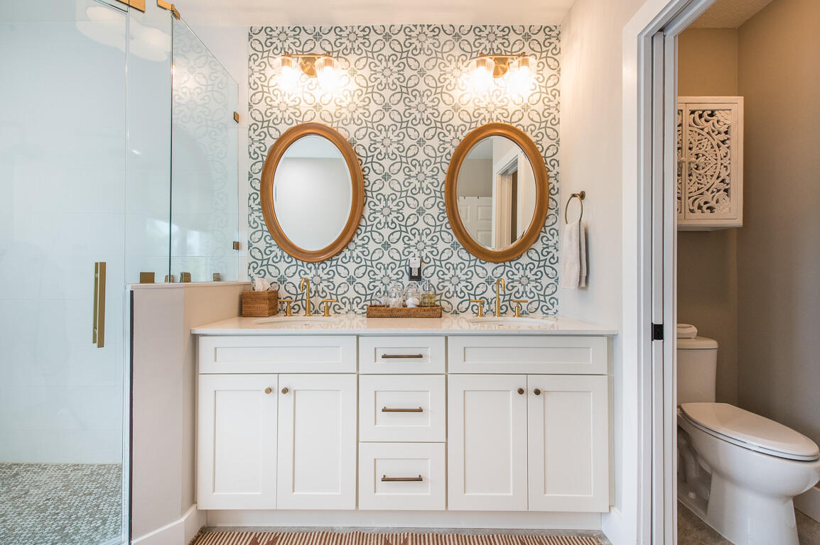 1910 Coastal Bay Boulevard Boynton Beach, FL 33435 - Photo 33 of 64 a bathroom with a granite countertop toilet a sink and a mirror