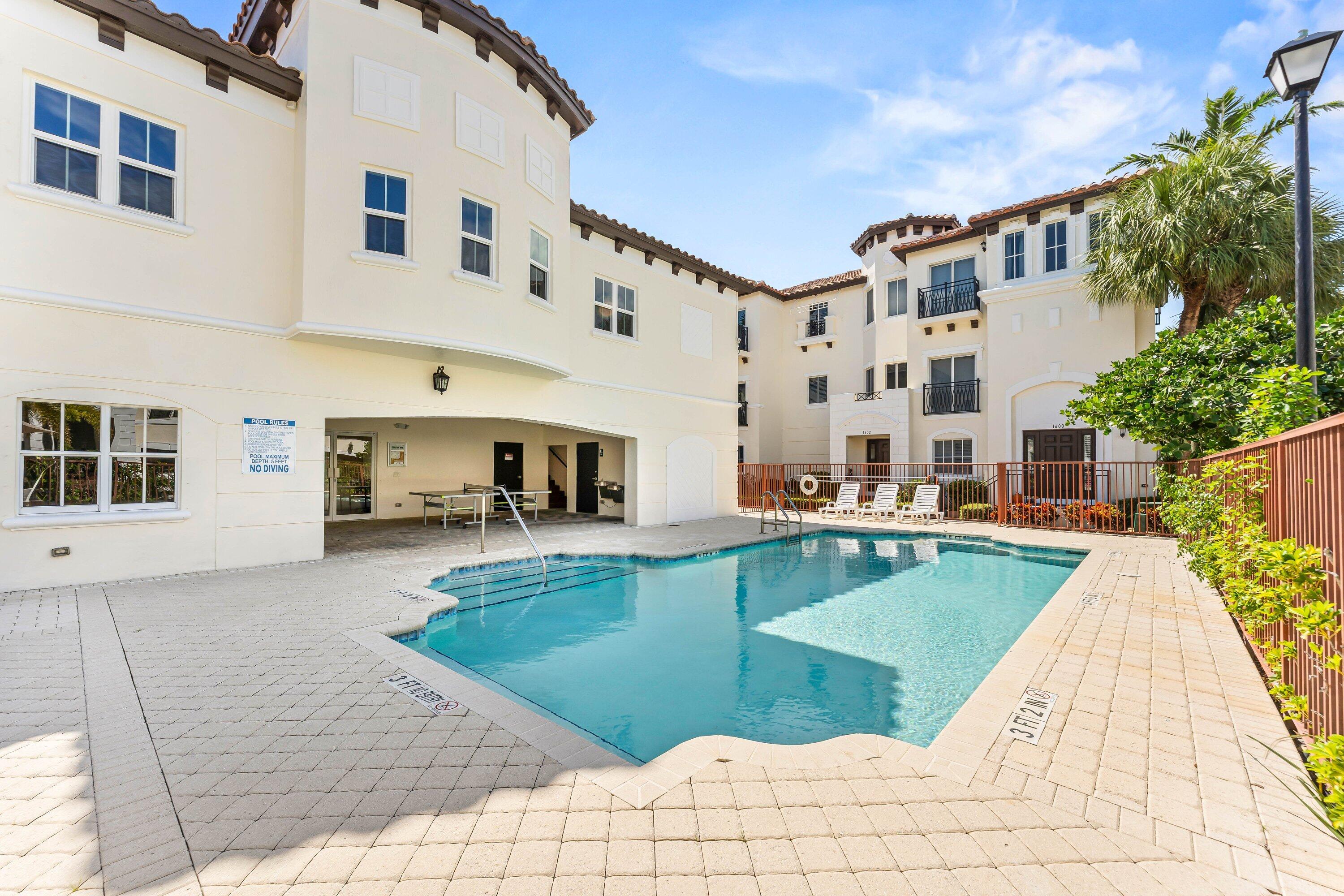 1910 Coastal Bay Boulevard Boynton Beach, FL 33435 - Photo 43 of 64 a view of a swimming pool with a lounge chairs