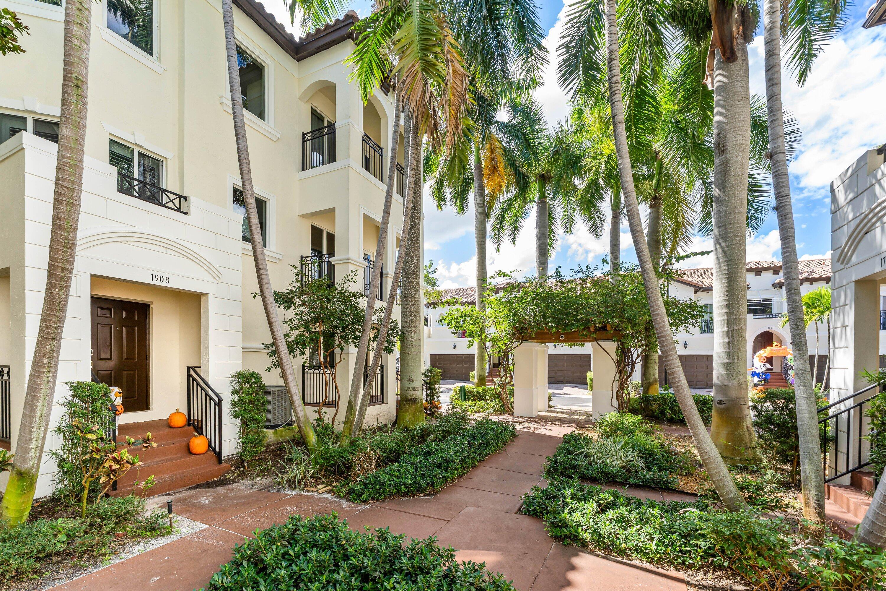 1910 Coastal Bay Boulevard Boynton Beach, FL 33435 - Photo 51 of 64 a front view of a multi story residential apartment building with a yard
