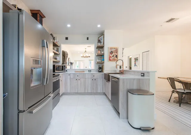 a kitchen with stainless steel appliances a sink stove and cabinets