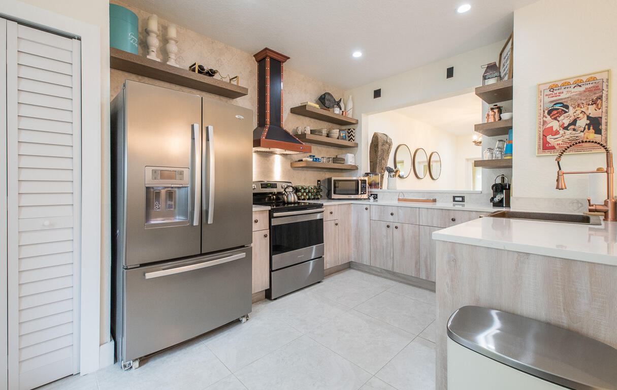 1910 Coastal Bay Boulevard Boynton Beach, FL 33435 - Photo 10 of 64 a kitchen with stainless steel appliances granite countertop a refrigerator a sink and white cabinets