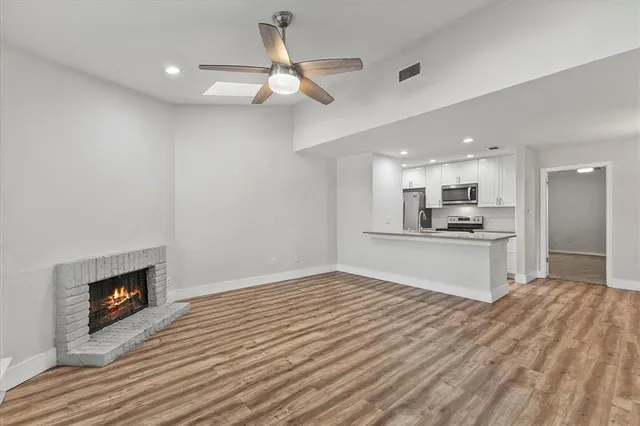 a view of kitchen with kitchen island wooden floor center island and stainless steel appliances