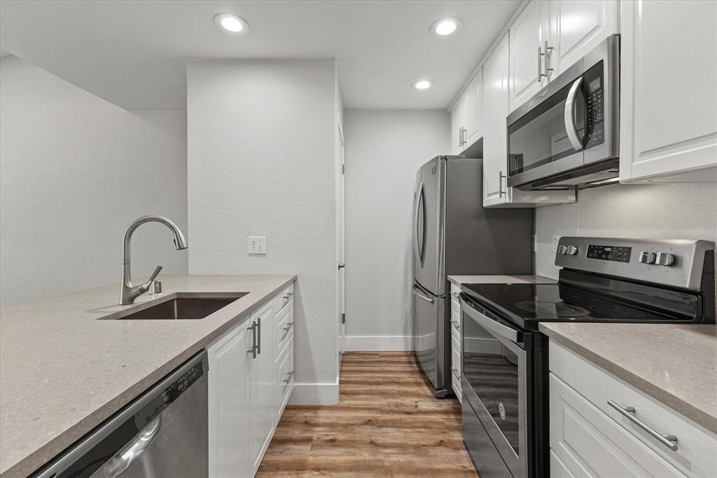 5616 Preston Oaks Road, Unit 208 Dallas, TX 75254 - Photo 9 of 16 a kitchen with stainless steel appliances granite countertop a sink and a refrigerator