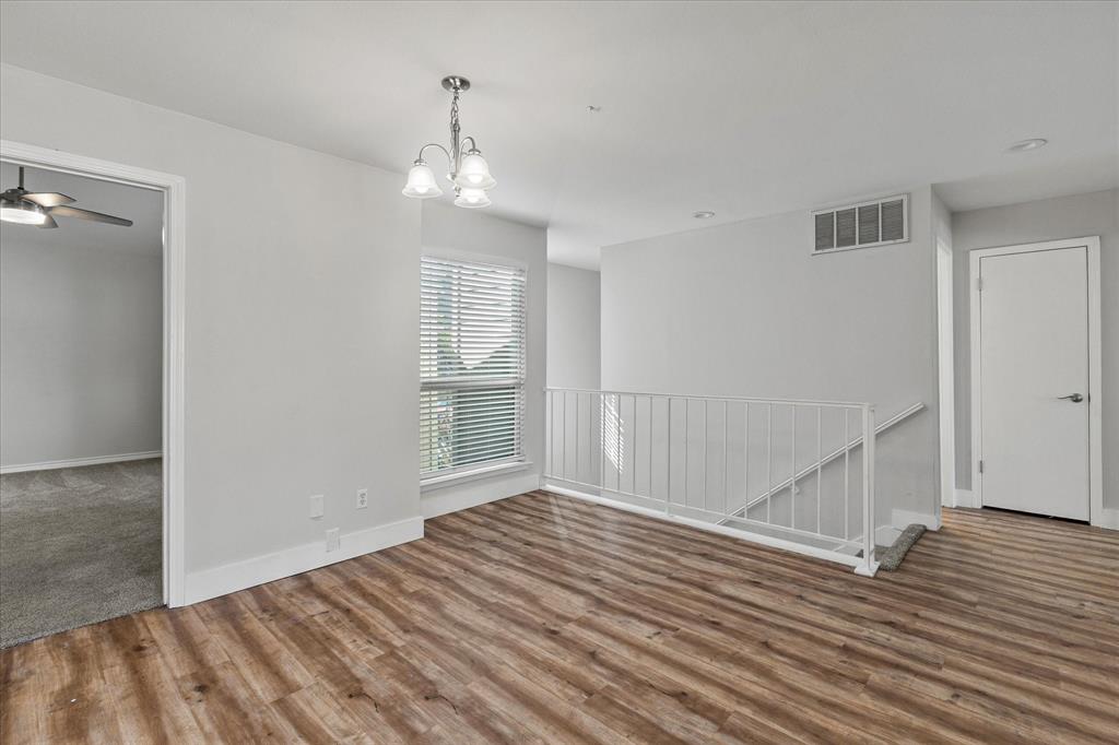 5616 Preston Oaks Road, Unit 208 Dallas, TX 75254 - Photo 10 of 16 a view of empty room with wooden floor and fan