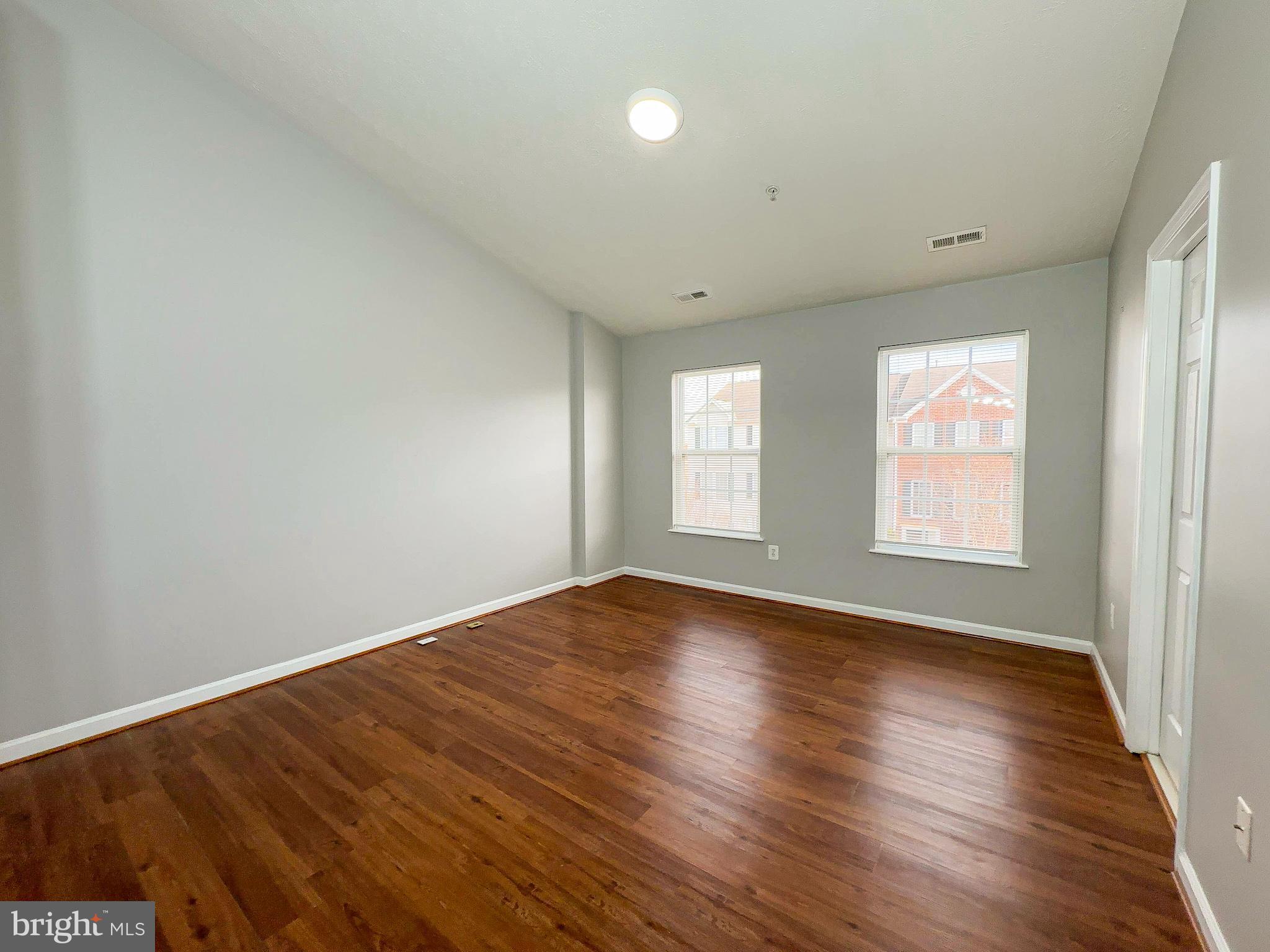 826 Lowe Road Baltimore, MD 21220 - Photo 12 of 35 an empty room with wooden floor and windows