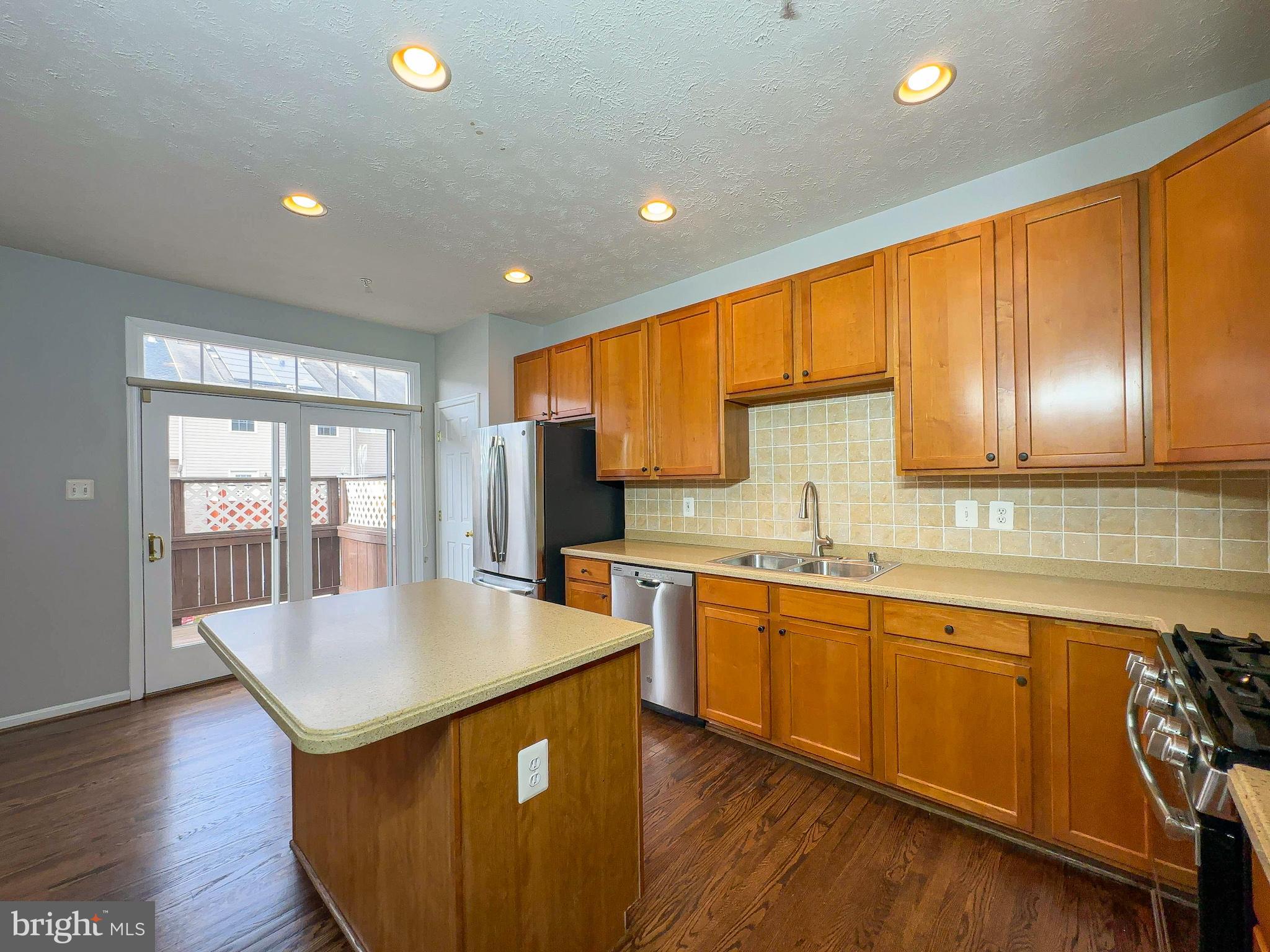 826 Lowe Road Baltimore, MD 21220 - Photo 15 of 35 a kitchen with stainless steel appliances granite countertop a sink a stove and wooden cabinets with wooden floor