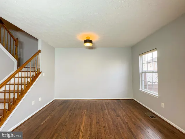 a view of livingroom with kitchen and wooden floor